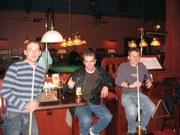 Dudes chilling with their pool sticks